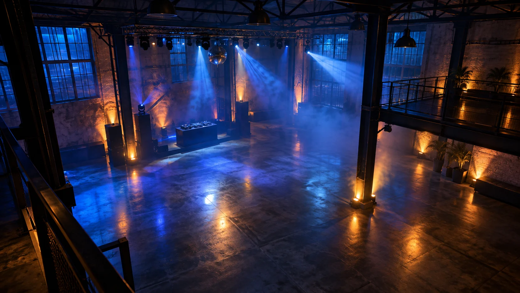 Blue and amber light beams cross an empty warehouse dance floor.